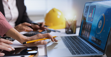 Workers entering data on a laptop