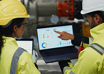 Two DDC controls technicians looking at a laptop display